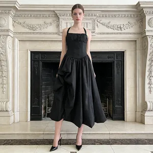 Full view of a French style black halter neck midi dress with a voluminous draped skirt