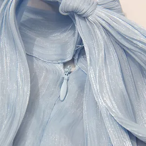 Nahaufnahme des verdeckten Reißverschlusses und Faltenstoffs an einem hellblauen Kleid