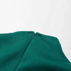Detailopname van de hoogwaardige onzichtbare rits op een elegante groene geplooide lange jurk