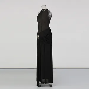 Détail d'une robe longue noire sans manches avec drapé plissé sophistiqué à la taille.