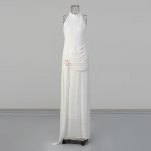 Détail d'une robe longue blanche sans manches plissée avec drapé élégant et boucle dorée