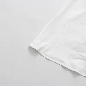 Macro view showing the fine stitching and finished hem detail on a white sleeveless dress