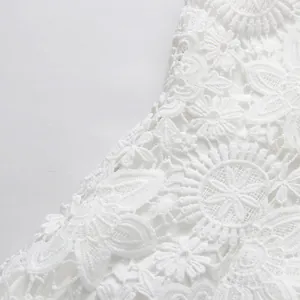 Close-up detail of intricate high-quality white lace embroidery on elegant sleeveless dress