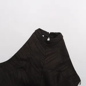 Détail en gros plan d'une robe noire à col montant avec une texture plissée verticale complexe