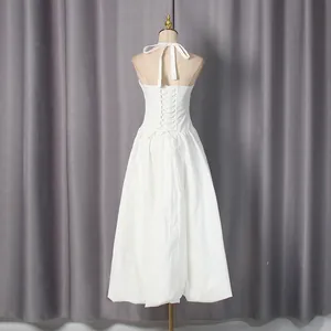 Back view detail of white halter dress with lace-up corset design and full skirt