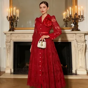 Elegantes rotes Spitzenkleid mit Blumenbrosche und Gürtel in luxuriösem Innenbereich