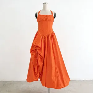 Detail view of an elegant orange sleeveless maxi dress on a mannequin