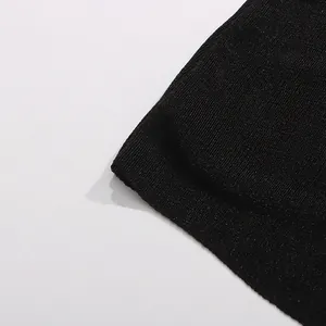 Détail rapproché du tissu en maille côtelée noire de haute qualité de cette robe longue