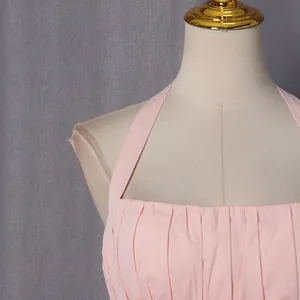 Macro view of a soft pink halter neck dress featuring elegant pleated bodice details