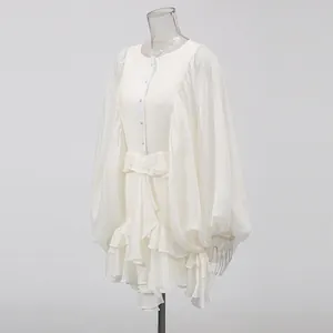 Detailed view of white Victorian style dress featuring lantern sleeves and ruffled hem