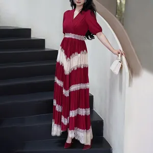 Détail d'une robe longue plissée rouge vintage française avec col en V et patchwork de dentelle.