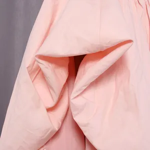 Detailed close-up of light pink fabric showing the soft texture and elegant drapery