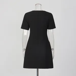 Back view detail of a classic black short-sleeved mini dress with a round neck design