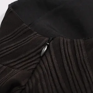 Gros plan sur la fermeture éclair cachée et les plis verticaux d'une robe noire