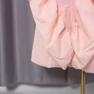Macro view showing the intricate pleats and soft pink fabric of the French style dress.