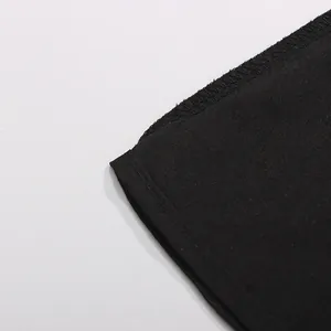 Gros plan détaillé montrant les coutures et l'ourlet de haute qualité de la robe noire