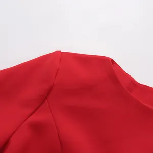 Close-up view of the round neckline and shoulder seam on this vibrant red fashion dress