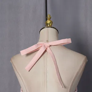 Close-up back detail of a pink French style dress featuring an elegant halter neck bow tie.