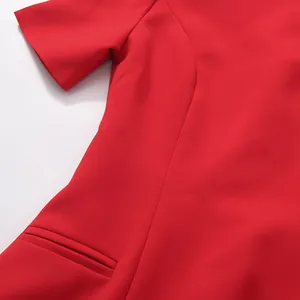 Detailed macro view showing the waistline tailoring and pocket of the red short dress.