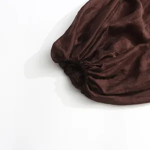 Close-up detail of dark brown lantern sleeve on a palace style dress with pleated fabric