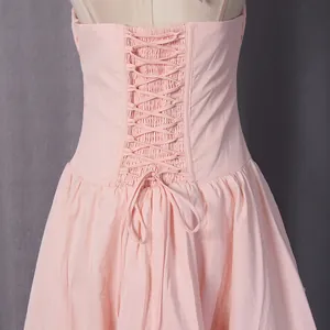 Close-up of the elegant lace-up back detail on a pink French-style dress for women.
