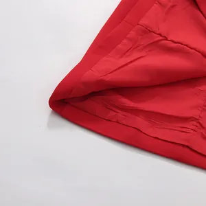 Close-up detail of a vibrant red dress showing fabric texture and smooth inner lining.