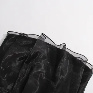 Primer plano del detalle de volantes de malla negra en un vestido ajustado de verano