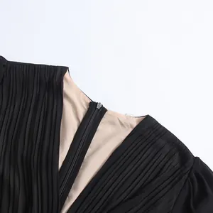 Détail de la robe plissée à col en V avec doublure contrastée et fermeture à glissière