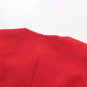 Detailed close-up of the invisible zipper and neckline on a solid red stylish dress
