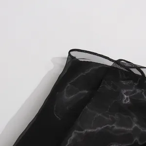 Primer plano del detalle de malla negra en un vestido de hombros descubiertos sin tirantes