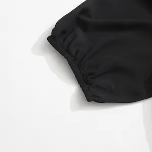 Gros plan détaillé montrant le poignet élastique d'une robe noire élégante de style rétro