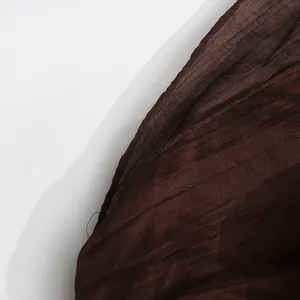 Detailed close-up of dark brown sheer chiffon fabric showing fine ribbed texture