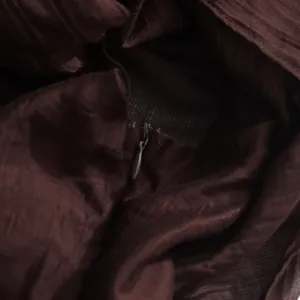Close-up detail of the concealed back zipper on a textured chocolate brown court dress