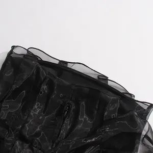 Detalle de las capas de malla negra y la cremallera invisible del vestido sin mangas