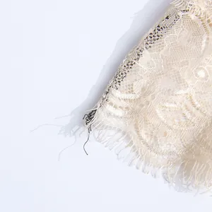 Détail de la dentelle florale crème délicate sur une robe de style vintage français