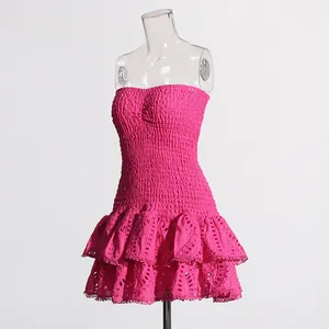 Detail van een fuchsia geborduurde strapless jurk met ruches en gesmokt lijfje