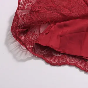 Nahaufnahme des aufwendig bestickten roten Spitzenkante und des glatten Futters dieses Kleides
