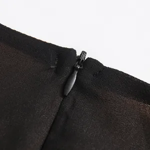 Détail de la fermeture éclair invisible sur une robe noire élégante de style rétro