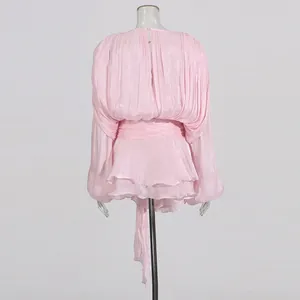 Detailed back view of pink pleated bubble sleeve dress with ruffle hem and tie waist