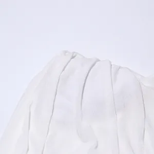 Nahaufnahme der hochwertigen Stoffstruktur und Drapierung eines eleganten weißen Abendkleids