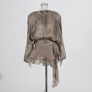 Detailed macro view of pleated fabric and ruffled hemline on a champagne mini dress