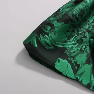 Close-up of green and black floral jacquard fabric detail on a spring maxi dress