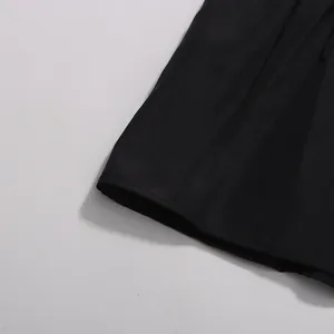Detailed close-up view of the black fabric texture and hemline for an elegant maxi dress