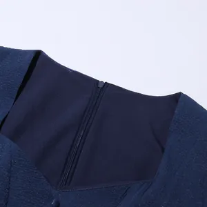 Dettaglio dello scollo quadrato e della cerniera invisibile sul retro di un abito blu