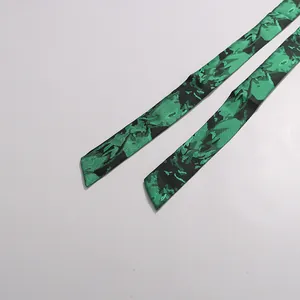 Close-up detail of green and black abstract printed waist tie for elegant midi dress