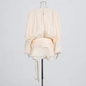 Rear view detail of champagne pleated mini dress featuring bubble sleeves and ruffled hem