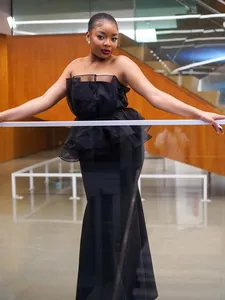 Elegante vestido ajustado negro palabra de honor con peplo de tul y falda de sirena