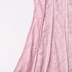 Close-up of elegant pink floral lace fabric and vertical piping on a long dress