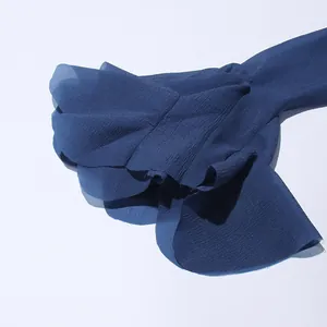 Dettaglio macro della manica a balze blu navy su un elegante abito in chiffon stile francese