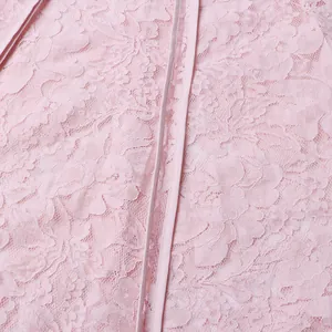 Detailed view of intricate pink floral lace fabric on long elegant dress